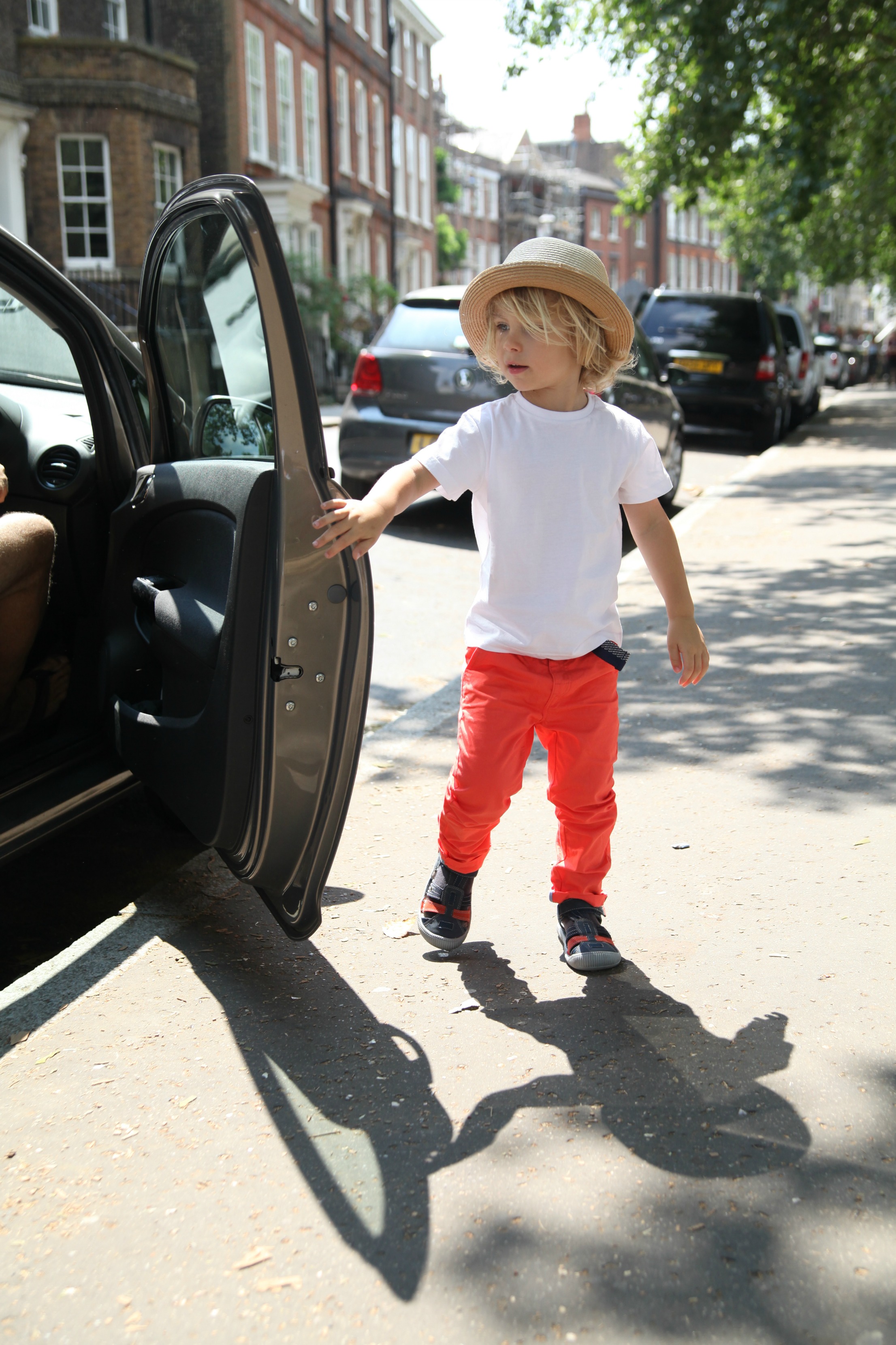 Boy opening car door dressed in Vertbaudet